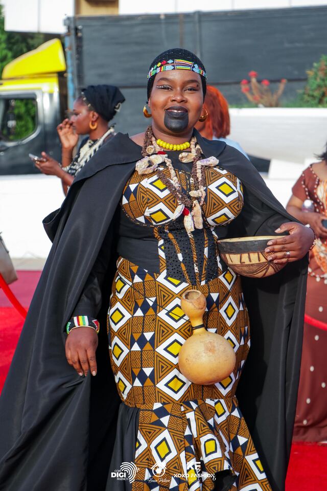Une invitée en cape noire, calebasse à la main